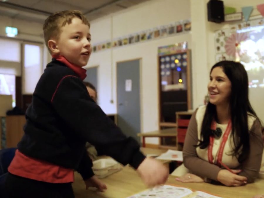 A staff member supporting a child in the classroom